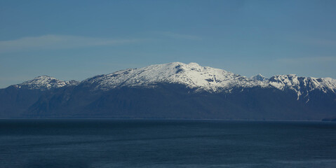 Fototapeta na wymiar scenic landscape photograph of the snowcapped mountains of Alaska from the ocean view.