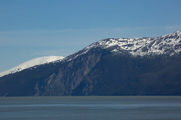 scenic landscape photograph of the snowcapped mountains of Alaska from the ocean view.