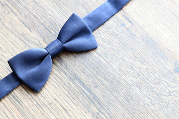 Navy blue bow tie on a wooden background