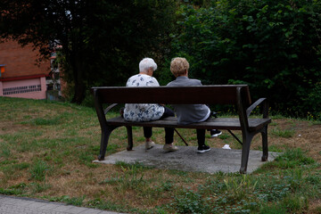 Two ageing women sat on a bench