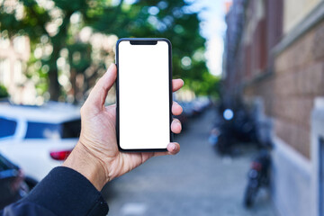 Man holding smartphone showing white blank screen at street