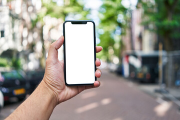 Man holding smartphone showing white blank screen at street