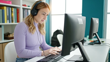 Young beautiful hispanic woman student using computer wearing headphones at library university