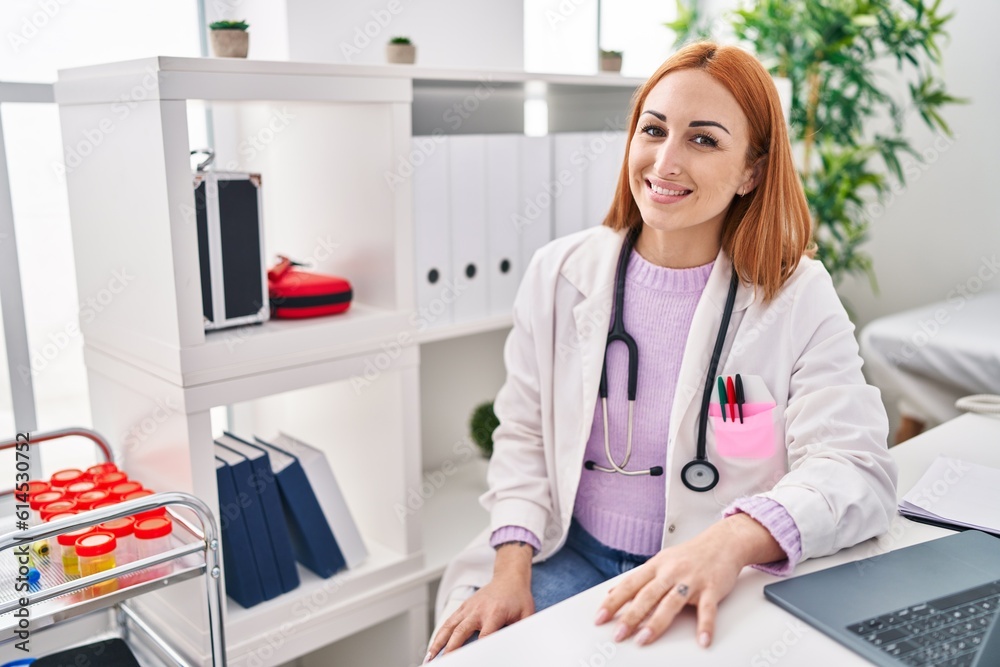 Sticker young caucasian woman doctor using laptop sitting on table at clinic