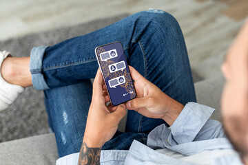 Cropped of stylish man sitting outdoors, using AI on smartphone