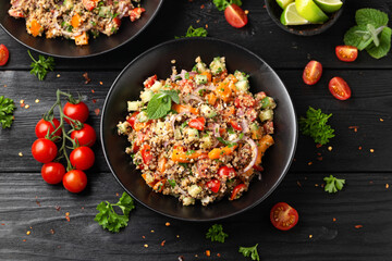 Red and white quinoa tabbouleh salad with tomatoes, paprika and mint. Vegetarian, vegan food concept - obrazy, fototapety, plakaty