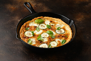 Sun baked tomato, goats cheese and courgette quiche served in cast iron pan with side salad