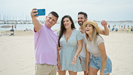 Group of people make selfie by smartphone smiling at beach