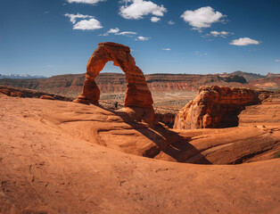 beautiful panorama of the delicate arch in the arches national park in moab, united states of america on a sunny day with blue sky and clouds.