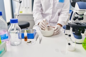 Fototapeta premium Young beautiful hispanic woman scientist mixing sample at laboratory