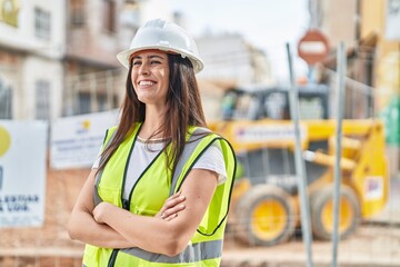 Young beautiful hispanic woman architect smiling confident standing with arms crossed gesture at street