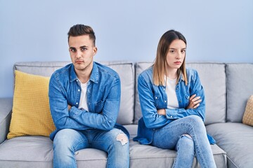 Man and woman couple unhappy sitting on sofa at home