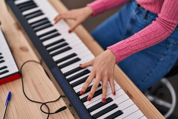 Obraz premium Young caucasian woman musician playing piano at music studio