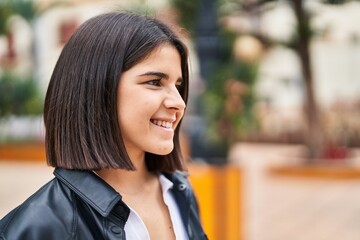 Young beautiful hispanic woman smiling confident looking to the side at park