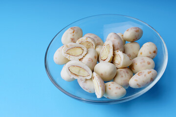 Almonds in white yogurt with coconut flakes on a blue background