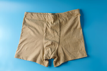 Big men's beige underpants on a blue background