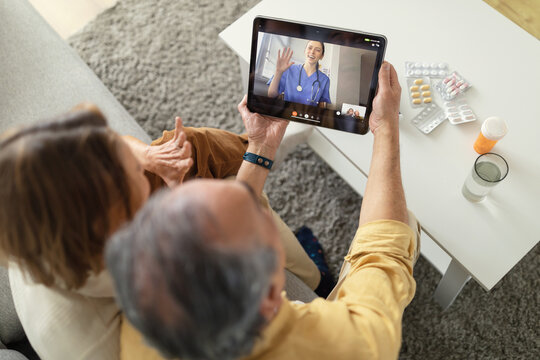 Telemedicine services. Senior spouses having video call with online doctor and getting professional health consultation