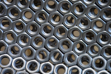 Metal nuts in a row background. Chromed screw nuts. Steel nuts pattern. Tools for work.