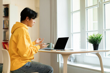 Korean learner using laptop to communicate having webinar at home