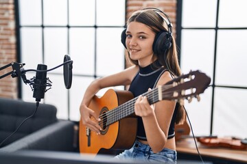 Adorable girl musician singing song playing classical guitar at music studio