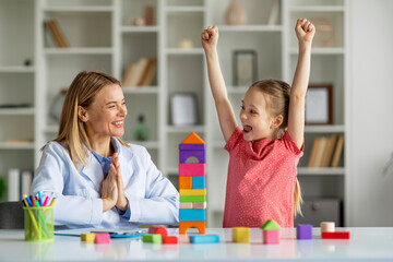 Cute Little Girl And Child Development Specialist Celebrating Therapy Progress