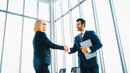 Business people handshake in corporate office showing professional agreement on a financial deal...