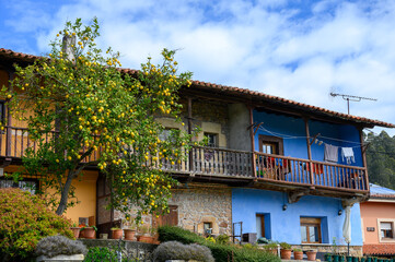 Fototapeta na wymiar Travelling by car in Asturias, North of Spain. View on village, houses, gardens near Villaviciosa