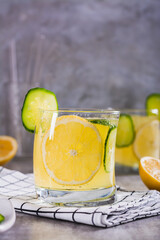 Refreshing lemonade with lemon, cucumber and ice in glasses on the table vertical view