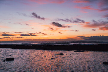 Gorgeous sunset at the beach with the colorful sky and the reflection on the water