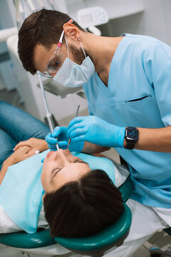 male dentist making treatment in modern clinic
