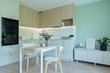 Luxurious kitchen with modern furniture, oven, table and chairs in stylish interior. Design architecture new in apartment.