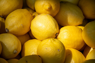 Many ripe yellow lemons citrus fruits on farmers market