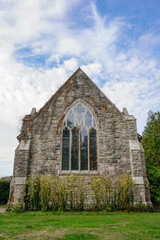 rear view of small chapel. Stone church exterior with large glass window. Religious building in the UK 