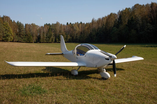 Small light airplane on green field