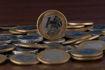 a 1 real Brazilian coin facing the camera in a pile of Brazilian coins