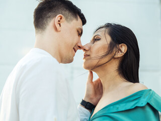A young loving couple of different nationalities admires the sunset near the water on the embankment.