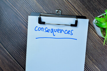 Concept of Consequences write on paperwork isolated on Wooden Table.