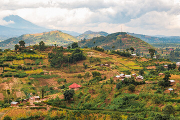 African landscapes with villages against Mount Muhabura in the  background at Kisoro, Uganda - obrazy, fototapety, plakaty