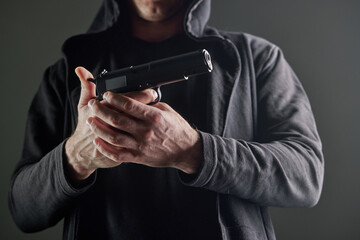 Male hand holding a gun on black background . A gun in a man's hand. defense or attack murderer or...