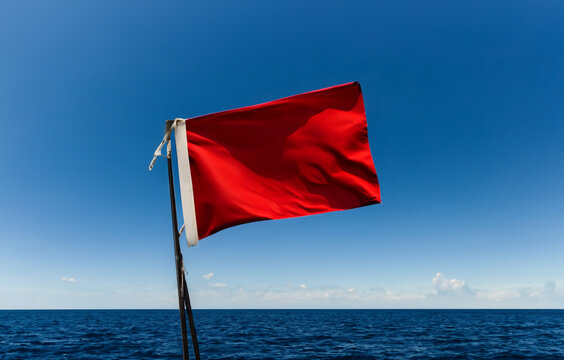 Flag waving out at sea on the ocean, flag left generic color so client can add their own overlay. Flag has wind ripples.