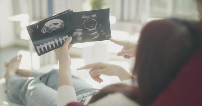 Roommate concept of 4k Resolution. Asian women looking at ultrasound results together in bedroom. Young women are in a mutual lesbian love relationship.