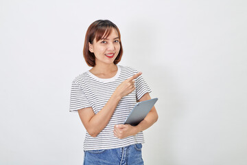 Portrait of a smiling beautiful Asian woman freelancer using a digital tablet and looking pleased with the device screen, shopping online, on white background