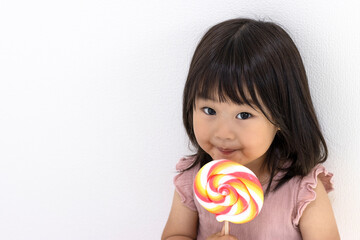 ペロペロキャンディを食べる女の子（日本人、2歳11か月）