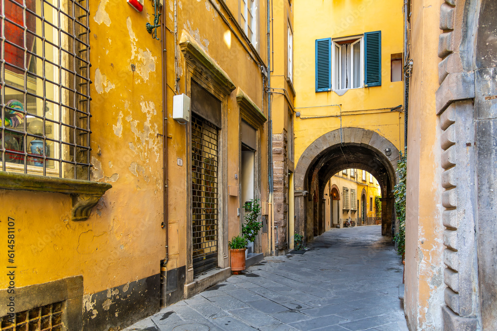 Wall mural a narrow alley with a short tunneled archway in the residential historic center of lucca, italy.