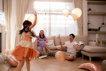 Happy asian family father and mother and daughter play balloon with enjoy and fun while celebration...