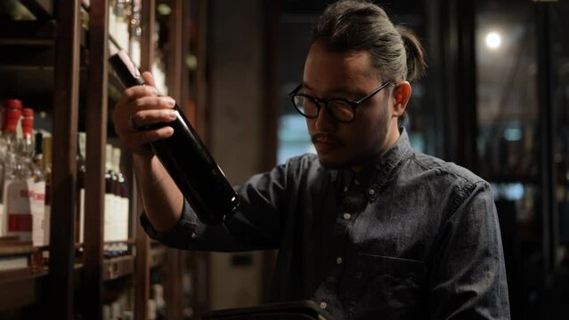 Night club concept of 4k Resolution. The bartender is checking the merchandise in the store. A group of specialized clubs that sell alcoholic beverages.