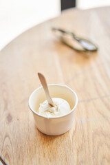 Vanilla ice-cream in disposable cups on the table. Italian gelateria. Natural fresh gelato. 