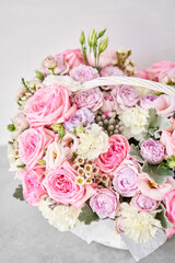 Flower arrangement in Wicker basket. Beautiful bouquet of mixed flowers on a marble table. Floral shop concept . Handsome fresh bouquet. Flowers delivery