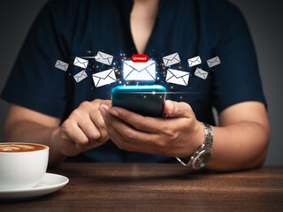 Business people using a mobile receive a new message with email icons while sitting at the table.