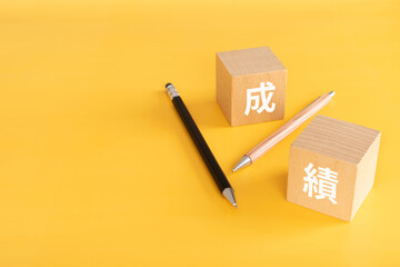 成績と書かれた積み木とペン